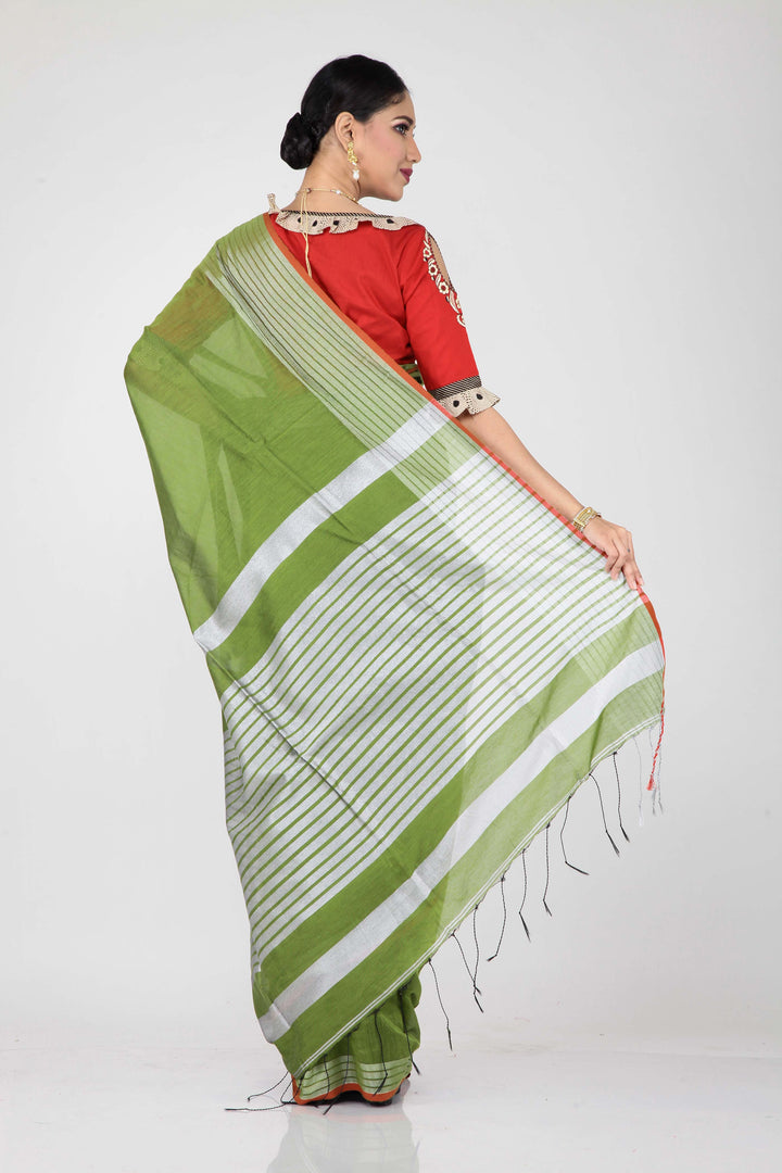 The lady is wearing a green handloom saree